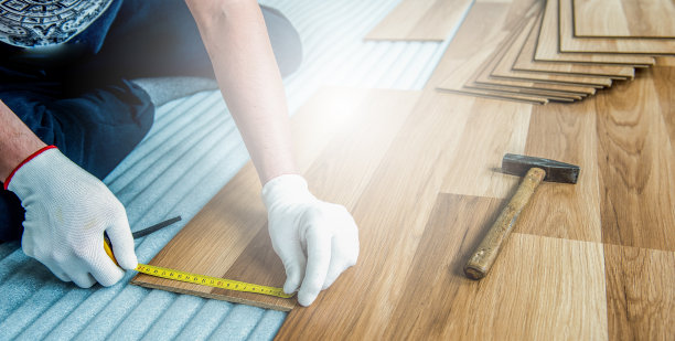 建筑工人正在房间里进行强化木地板的铺设和维修整理工作图片下载