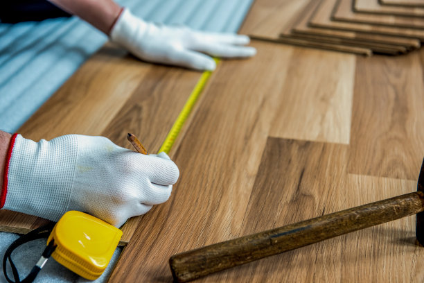 建筑工人正在房间里进行强化木地板的铺设和维修整理工作图片下载