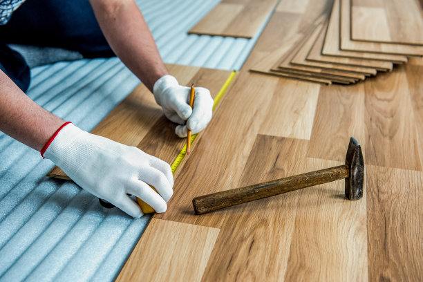 建筑工人正在房间里进行强化木地板的铺设和维修整理工作图片下载
