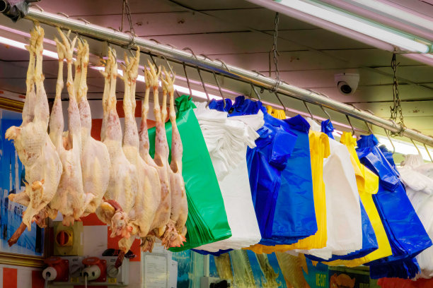 英国伦敦，一个市场摊位上挂着新鲜鸡肉、家禽和塑料袋图片下载