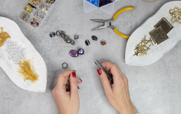 女性制作手工珠宝。手工串珠准备图片下载