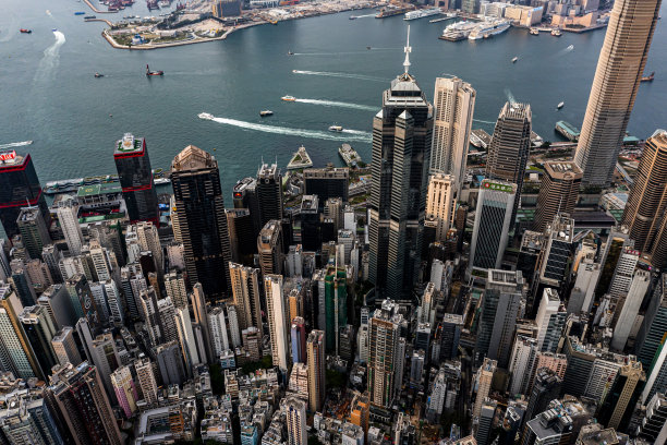 多云天气下的香港空中城市景观。城市摩天大楼和亮着灯的港口图片下载