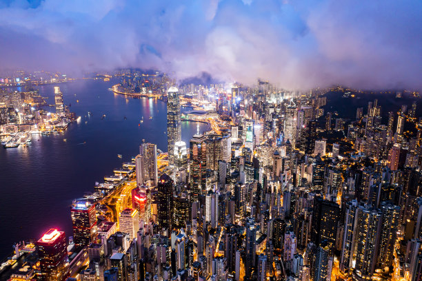 香港夜间的空中城市景观。城市摩天大楼和亮着灯的港口图片下载