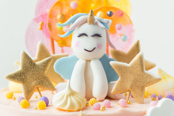 独角兽蛋糕，粉色奶油奶酪糖霜装饰乳脂彩虹，彩色焦糖糖果和独角兽形状的人在上面。白色背景上有一个小女孩的生日蛋糕图片下载