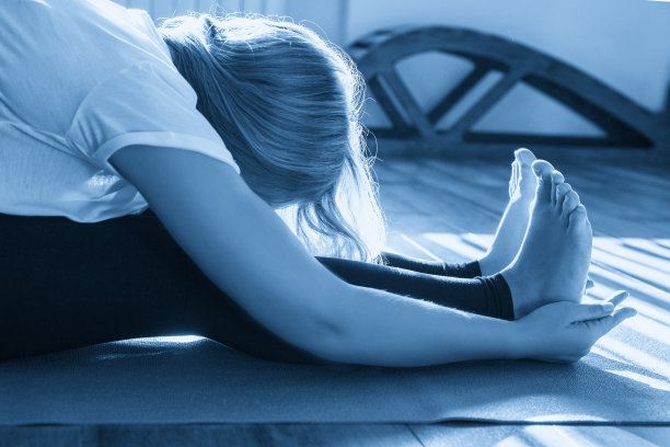 美丽的年轻女子在垫子上伸展瑜伽姿势图片下载