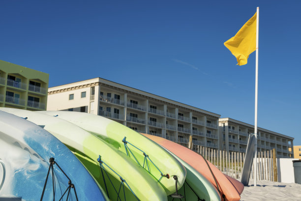 佛罗里达州德斯汀酒店大楼前的一根杆子上挂着黄旗，附近有皮划艇出租图片下载