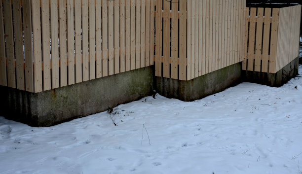 带混凝土衬里的木板栅栏。这些木板没有涂漆，是垂直放置的。乡村花园的乡村外观带有锯齿状的楼梯，不透明图片下载
