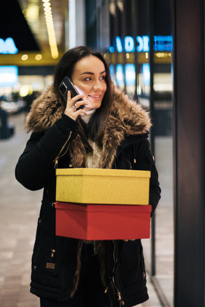 年轻的女人拿着箱子去购物。图片下载