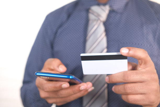 男子手持信用卡，用智能手机在网上购物图片下载