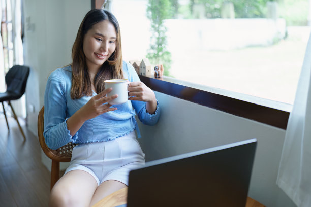 女商人坐着喝咖啡，笑得很开心图片下载