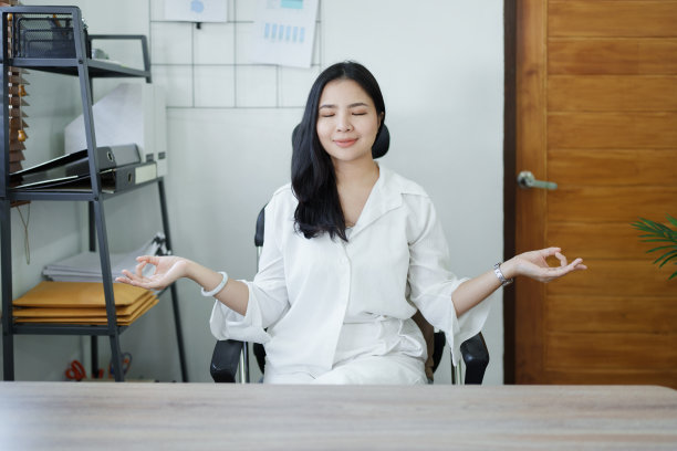 年轻的亚洲妇女在工作前冥想瑜伽姿势的肖像图片下载
