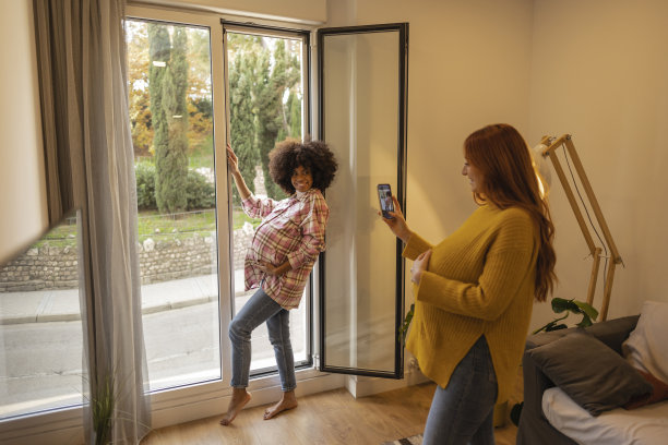 两个不同种族的怀孕朋友拍照留念，焦点在非裔美国女性身上图片下载