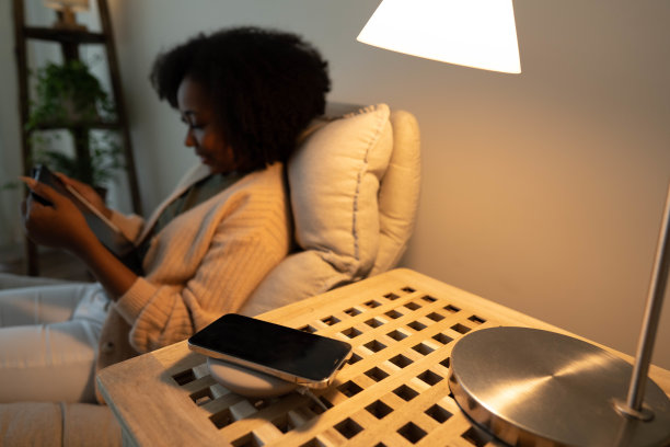 一名女子将智能手机放在无线充电器上图片下载