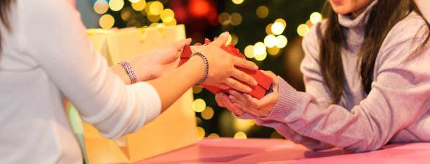 近距离牵手，跨年夜交换新年礼物。圣诞节或新年的礼品盒图片下载