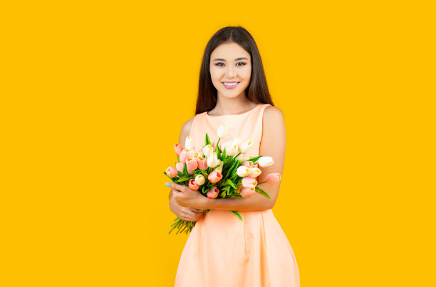 亚洲妇女与花束在黄色背景，复制空间。图片下载