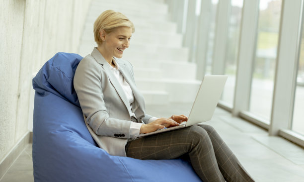 女商人使用笔记本电脑在懒懒的包在现代办公室图片下载