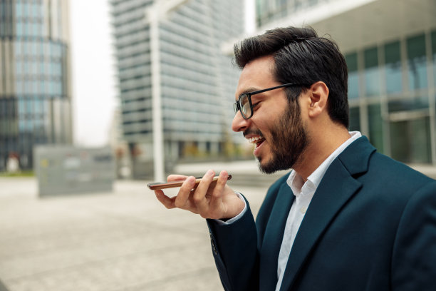 印度商人在休息时站在办公室附近给客户录音图片下载