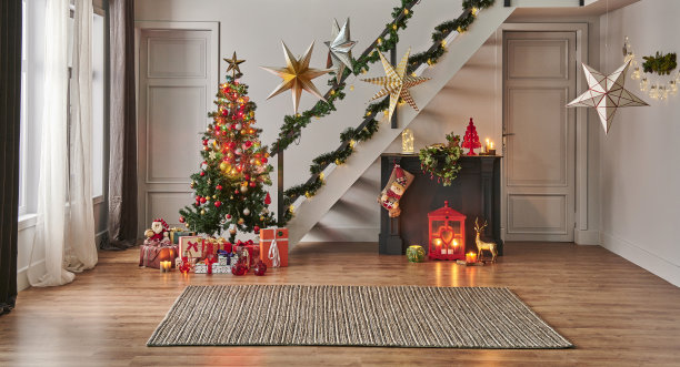 现代沙发圣诞新年概念与松树礼盒和壁炉，装饰led灯，楼梯和门背景，灰色墙壁，柳条地毯设计。图片下载