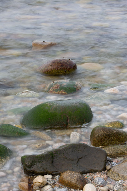 沙滩上水下的鹅卵石的垂直镜头图片下载