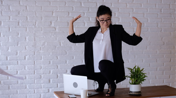 在功能区，身着商务风格的办公室员工在舞蹈中自由放松。女孩在工作的桌子上跳舞，撒着文件。快乐的办公室浮游生物。图片下载