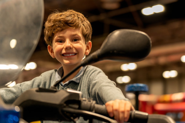 快乐的男孩在商场的车辆上图片下载