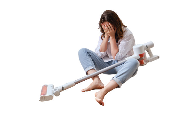 厨房里一个拿着无线便携式吸尘器的哭泣的女人，被孤立在白色背景上。一个悲伤的女人在用吸尘器打扫公寓的地板图片下载