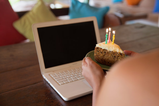 一个不认识的女人拿着一块生日蛋糕和点燃的蜡烛图片下载