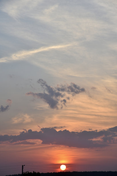 美丽的日落，夏天的天空，云和飞行的飞机。夕阳在傍晚的天空。图片下载