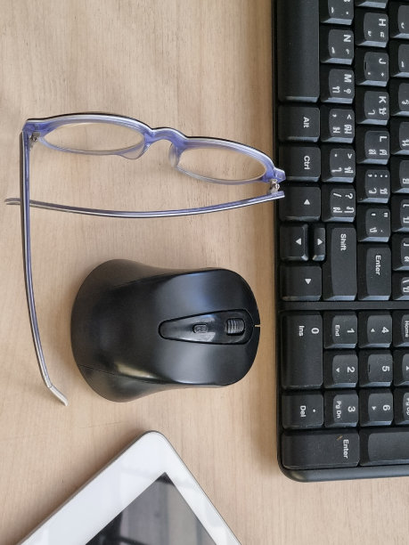 桌上有平板电脑、电脑键盘、鼠标和眼镜。图片下载