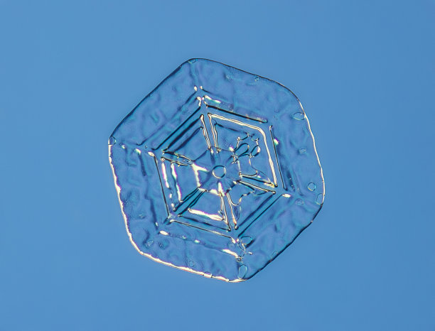 雪花在平滑的渐变背景。微距照片的真正雪水晶玻璃表面。这是一个图案不寻常的小雪花晶体图片下载