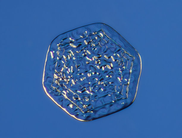 雪花在平滑的渐变背景。微距照片的真正雪水晶玻璃表面。这是一个图案不寻常的小雪花晶体图片下载