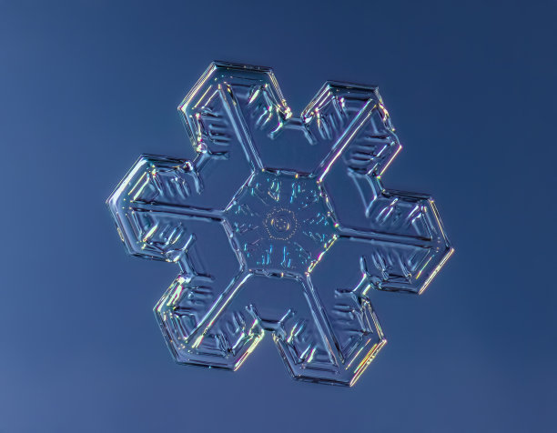 雪花在平滑的渐变背景。微距照片的真正雪水晶玻璃表面。这是一个图案不寻常的小雪花晶体图片下载