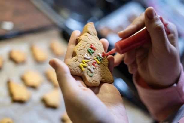 青少年正在厨房制作圣诞饼干，重点是前景水平照片图片下载