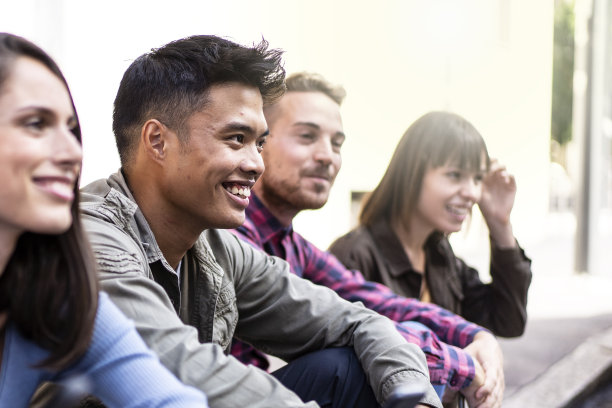 大学后院没有智能手机的多元文化人群-快乐的千禧一代朋友一起坐在街上玩-对比度滤镜图片下载