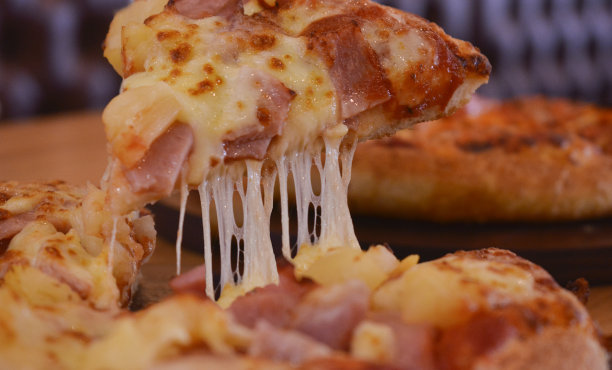 披萨是盛在盘子里的美味的彩色披萨。图片下载