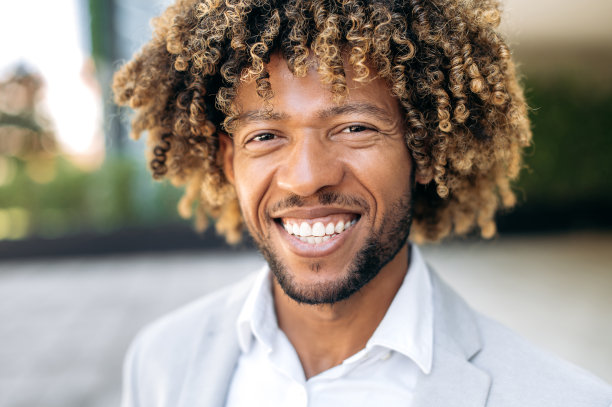 特写照片的一个英俊的有吸引力的自信卷发拉丁美洲或巴西人，穿着时尚，混合种族成功的执行官，站在户外，看着相机，微笑友好图片下载