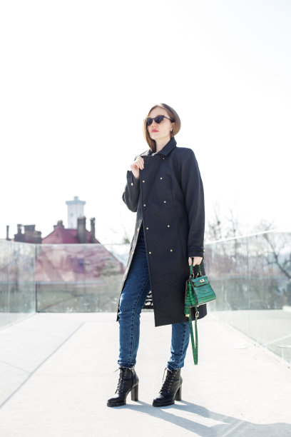 年轻的女孩戴着太阳镜，金色的长发在风中飘扬，外面穿着一件长外套图片下载