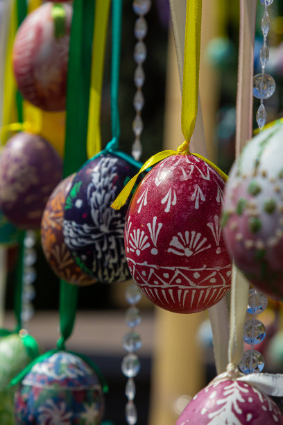 彩绘的彩蛋挂在复活节树的树枝上。重点是一个黄色的鸡蛋由孩子们手绘。图片下载