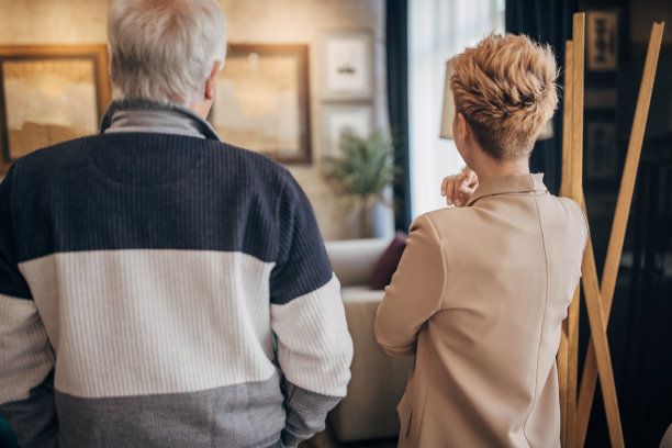 父女俩边看画边谈生意图片下载