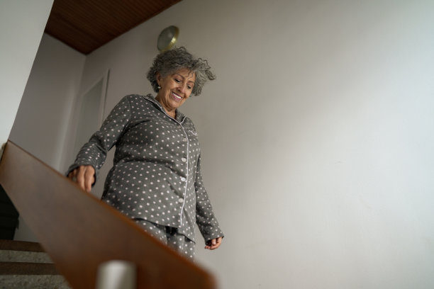 退休的女士正在家里休息，她正走下楼梯图片下载
