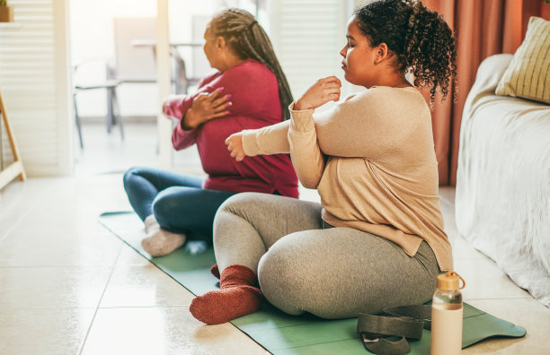 母亲和女儿一起在家做健身运动-冬季的家庭和运动概念-专注于女孩的手图片下载