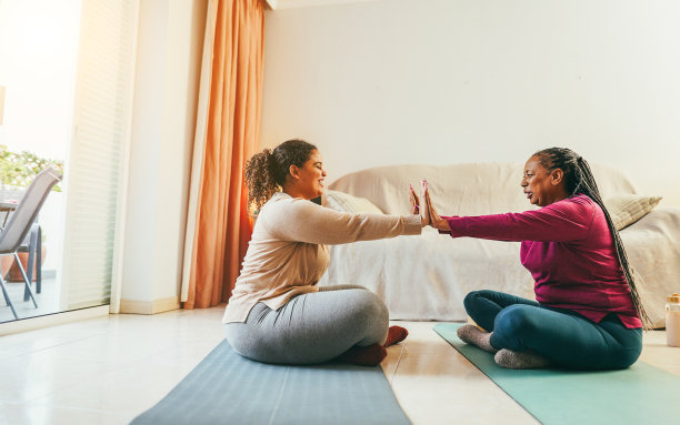 母亲和女儿在家里一起做健身运动-冬季的家庭和运动概念-专注于手图片下载