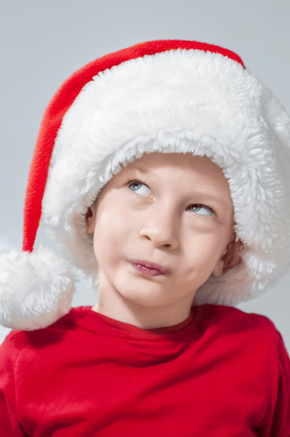 一个戴着圣诞老人帽子的孩子在梦中抬头。高质量照片图片下载