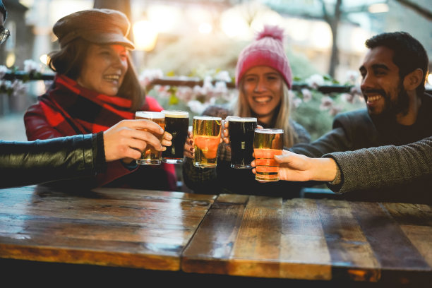 年轻人在酒吧餐厅用啤酒欢呼——右手拿着杯子图片下载