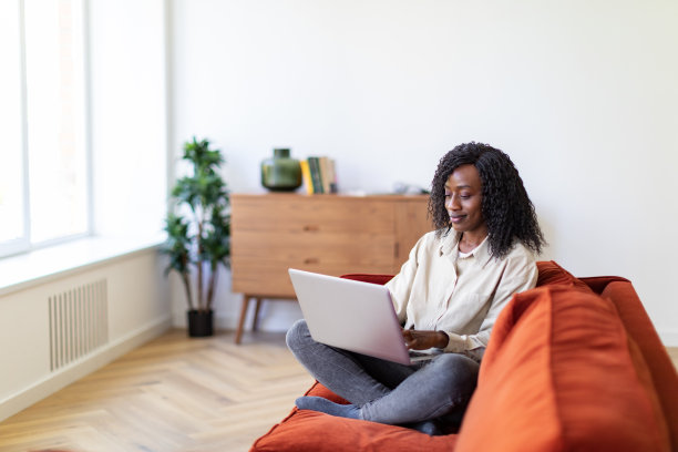 年轻的黑人妇女在家里用笔记本电脑工作图片下载