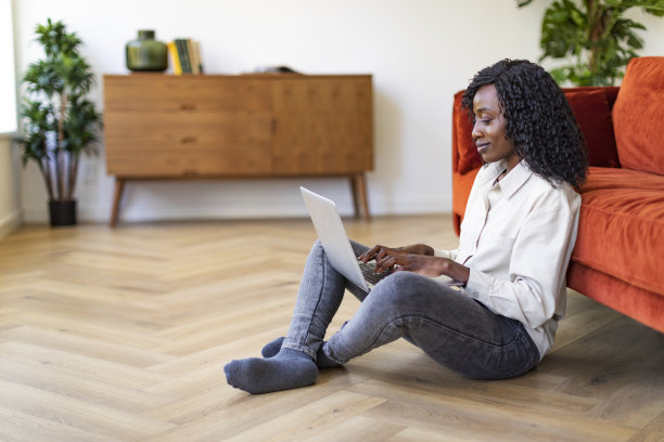 年轻的黑人妇女在家里用笔记本电脑工作图片下载