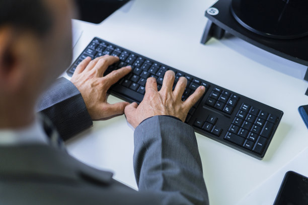 一位老人的手在他的办公室里摆弄着他的电子媒体图片下载