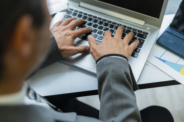 一位老人的手在他的办公室里摆弄着他的电子媒体图片下载