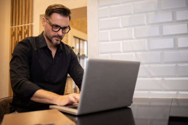 年轻时尚的男人在家里工作图片下载