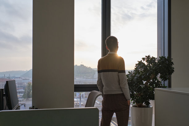 商业环境——商人站在办公室，看着窗外图片下载